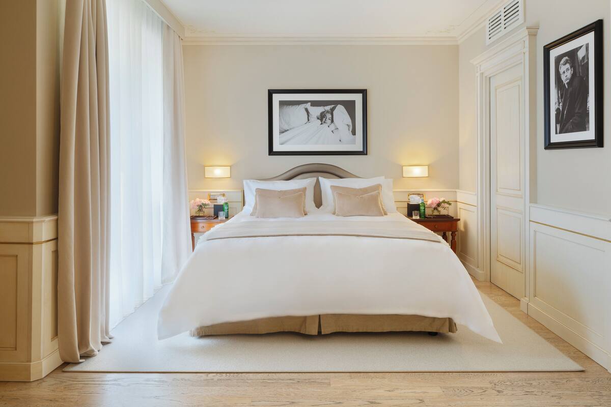 A neatly arranged bedroom with a large bed, two bedside tables, and a framed picture on the wall.