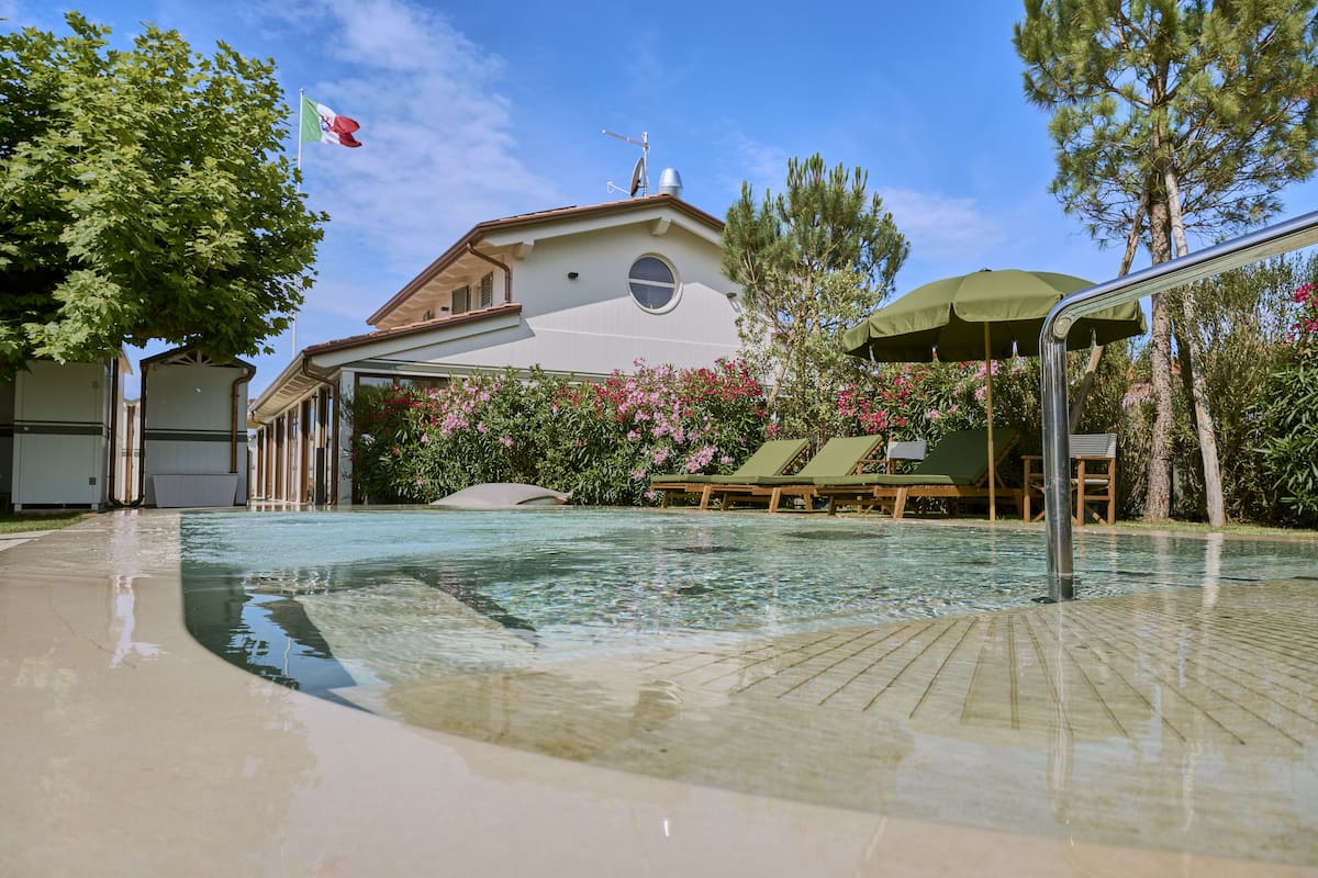A swimming pool area with lounge chairs and a flag.