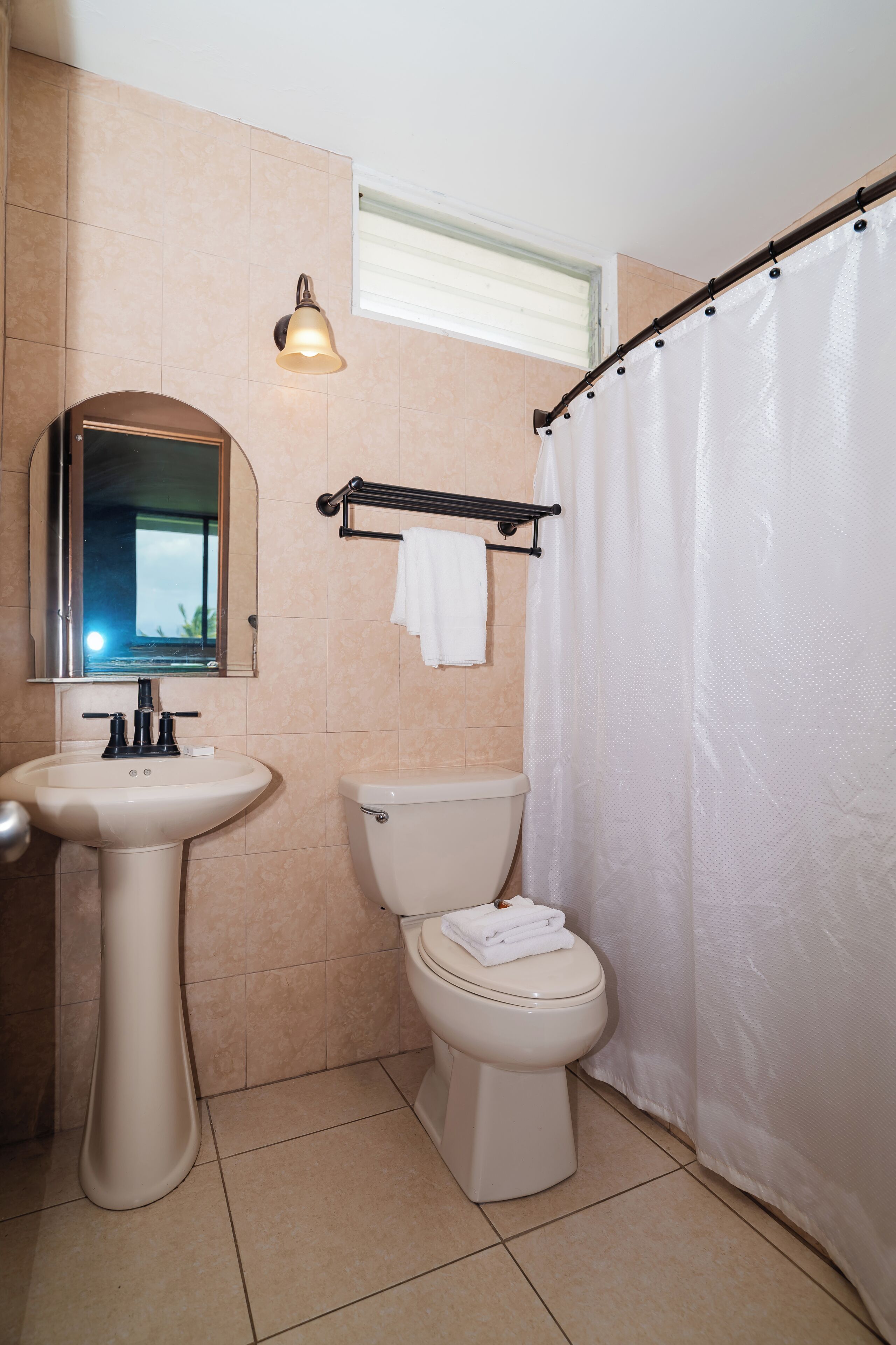 A bathroom with a sink, toilet, and shower curtain.