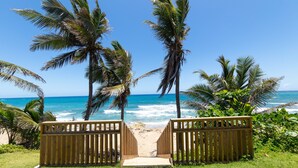 A wooden gate leading to a beach with palm trees and ocean views. - Hotel El Guajataca (Quebradillas)