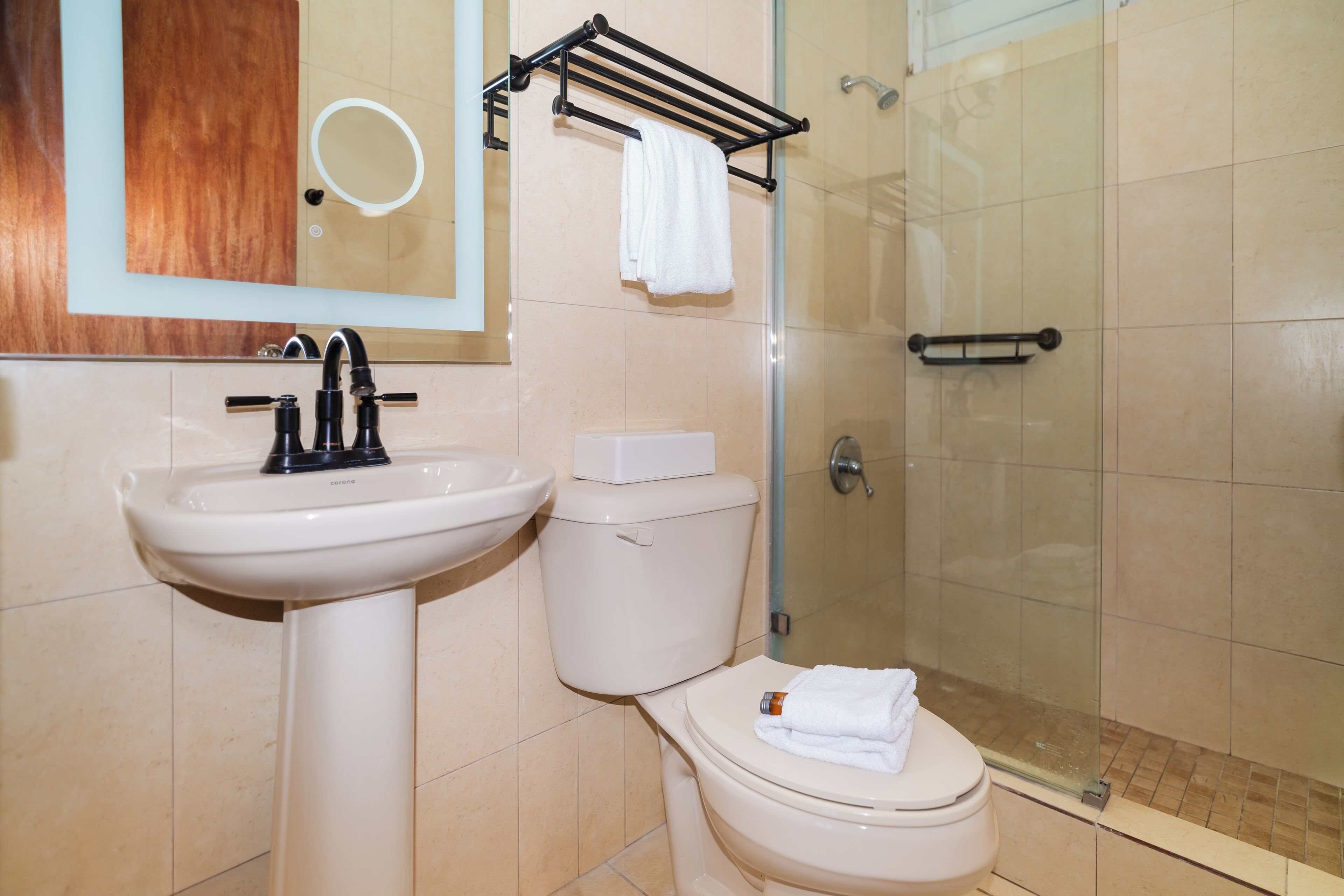 Une salle de bain équipée d’un lavabo, de toilettes et d’une douche à parois en verre.