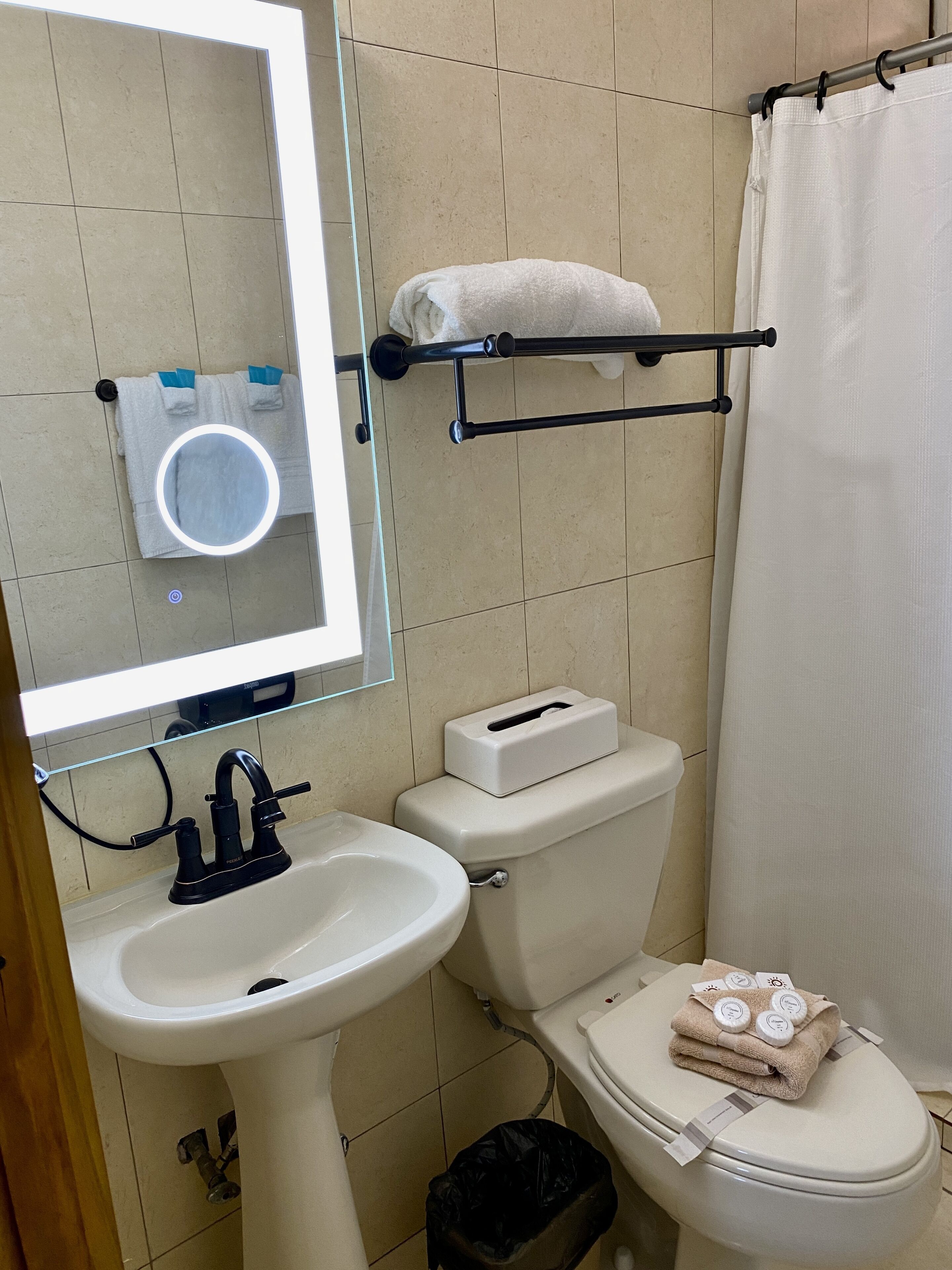A bathroom with a sink, toilet, and a towel rack.