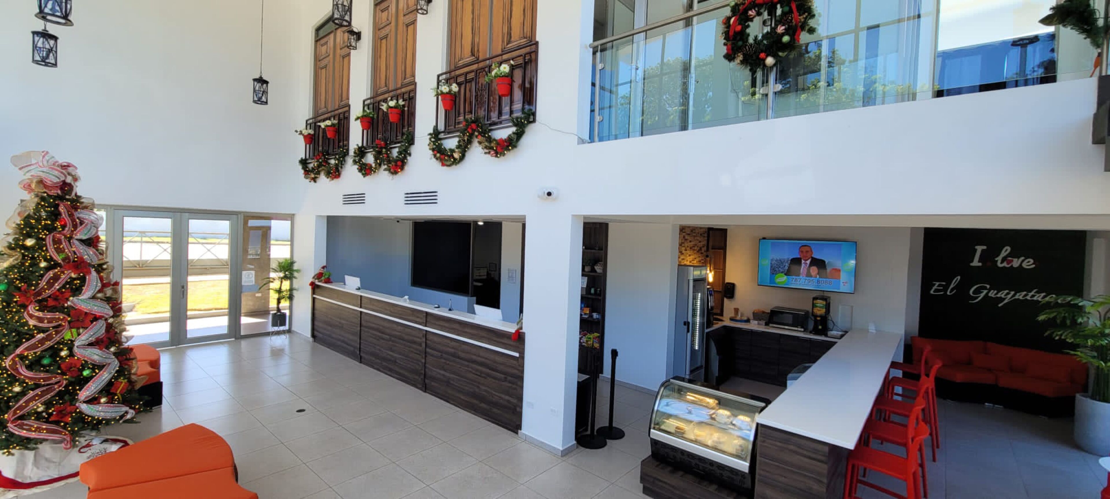 Eine moderne Hotelhalle mit Weihnachtsbaum, einer Rezeption und einer Sitzecke.