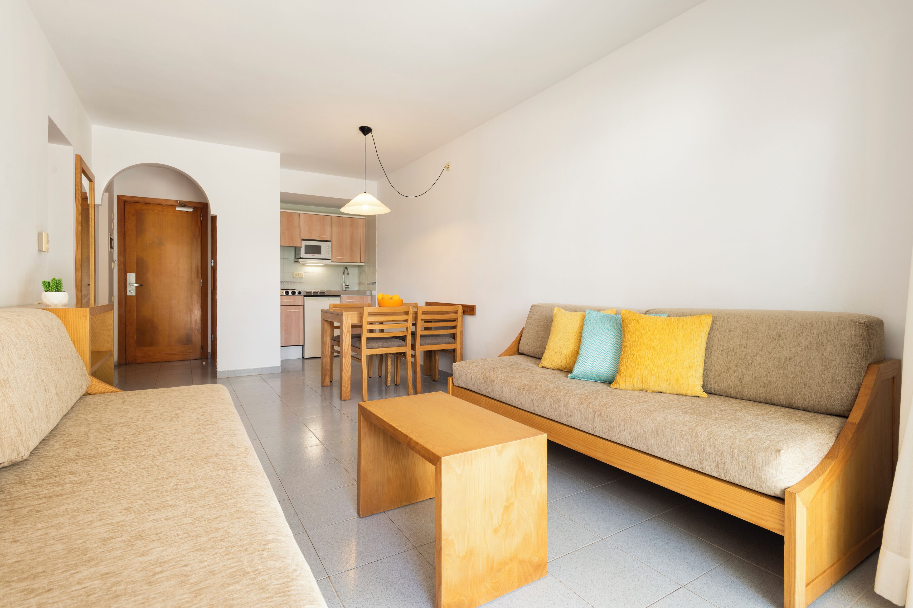 A modern living room with a sofa, coffee table, and dining area.