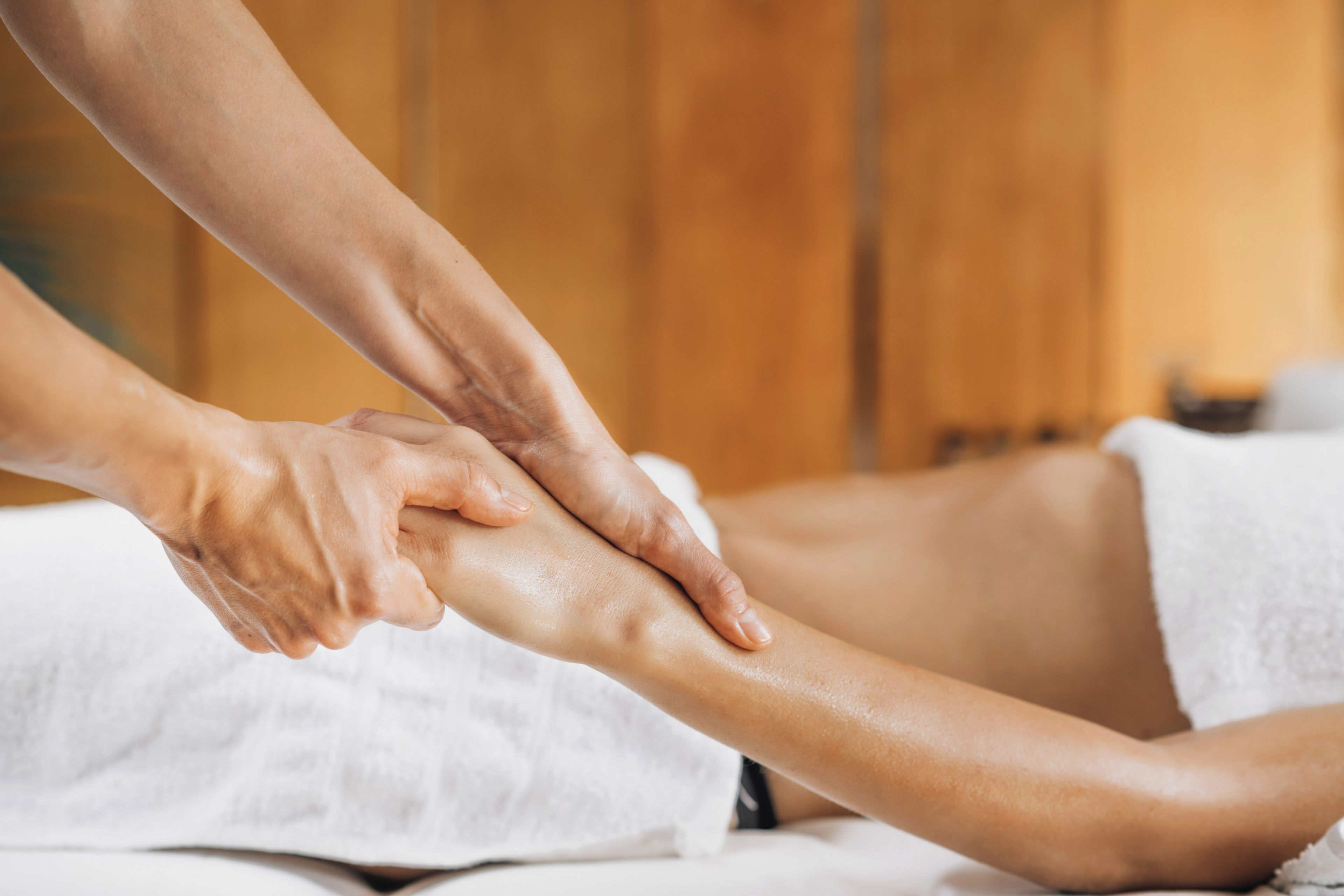 Sesión de terapia de masajes enfocada en las manos del terapeuta y la pierna del cliente.