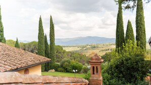 A villa with a tiled roof, a bell tower, and a view of the countryside. - Agriturismo Vecchio Borgo di Inalbi (Impruneta)