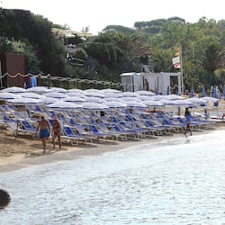 Praia particular, areia branca, espreguiçadeiras, guarda-sóis