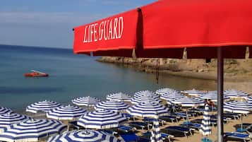Playa privada, arena blanca, sillas reclinables de playa, sombrillas