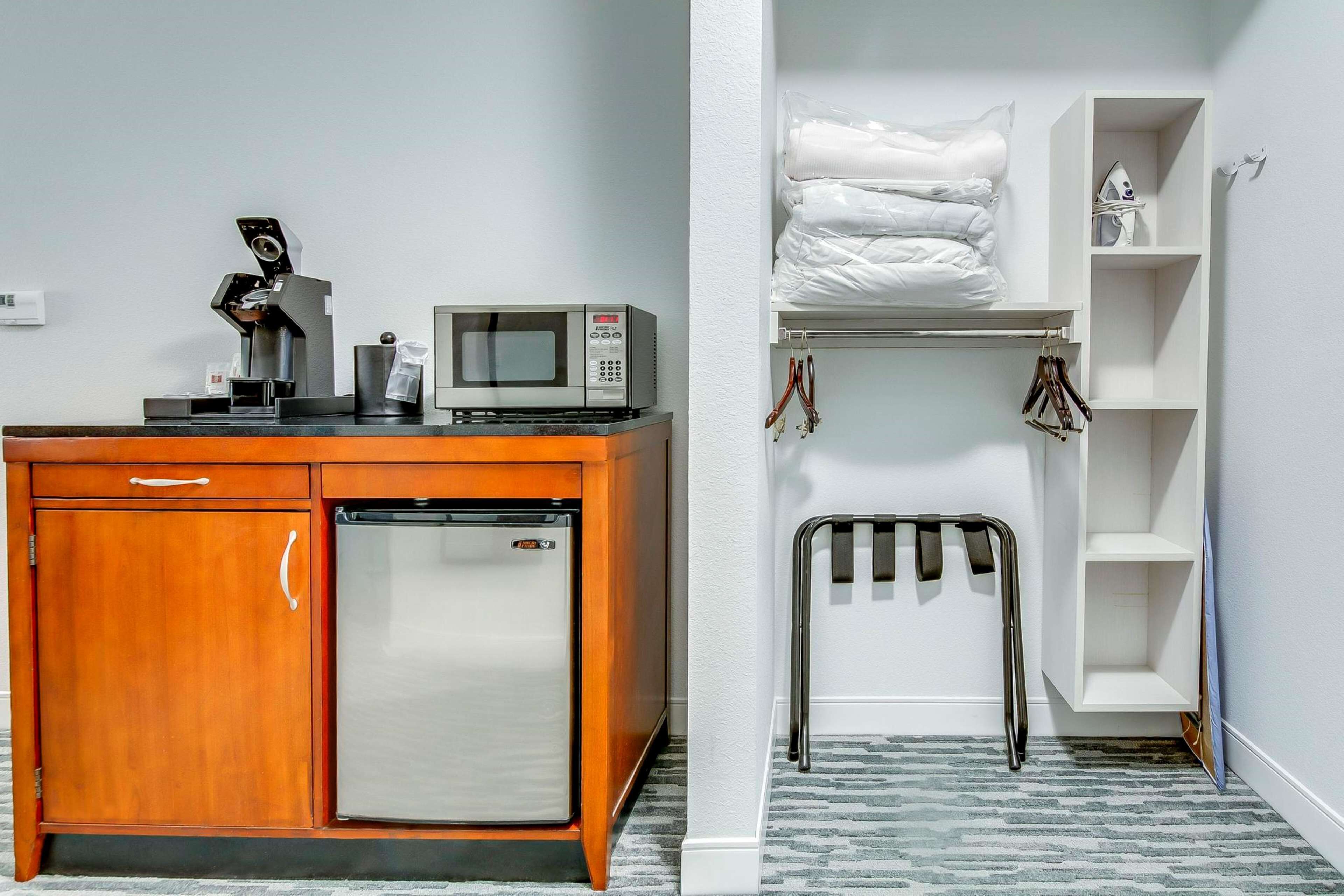 A compact kitchenette with a refrigerator, microwave, and coffee maker.