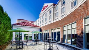 A hotel with outdoor seating and a red-brick facade.