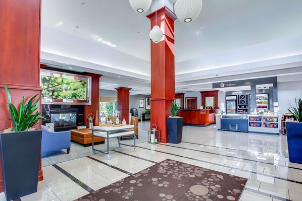 A spacious lobby with a reception desk, a coffee station, and a seating area with a fireplace.