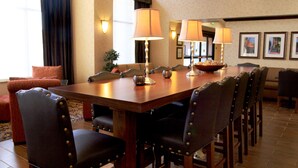 Un comedor con una mesa de madera, varias sillas y lámparas.