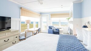 A bedroom with a bed, a TV, a desk, and a chair.
