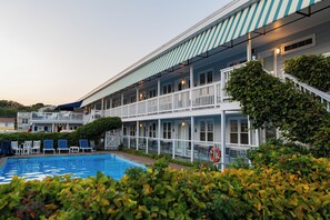 A hotel with a pool, outdoor seating, and a covered balcony area. - The Edgewater (Old Orchard Beach)