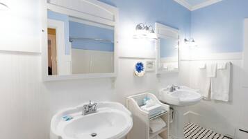 Une salle de bain avec deux lavabos, un miroir et un porte-serviettes.