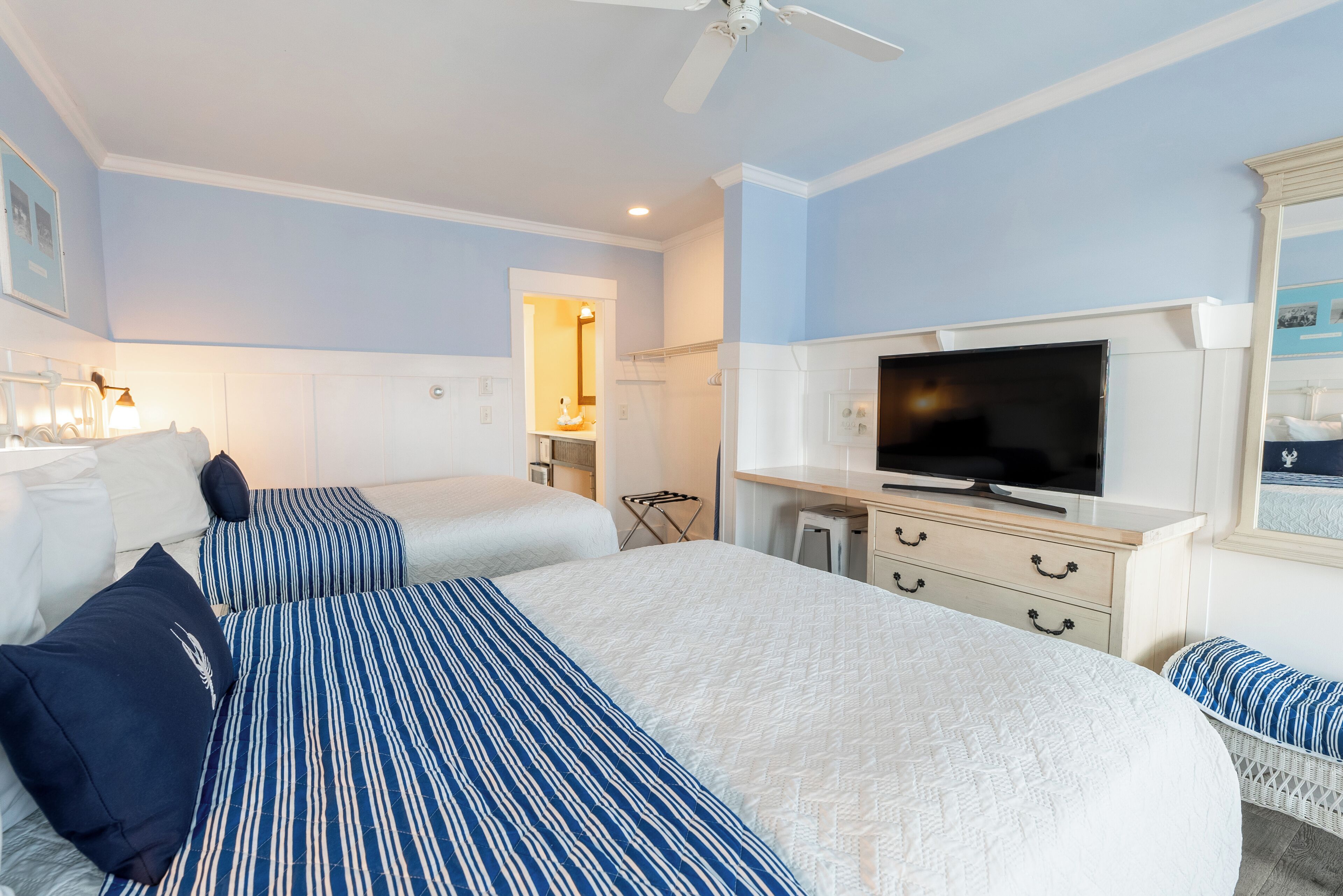 A hotel room with a large bed, a television, and a small seating area.