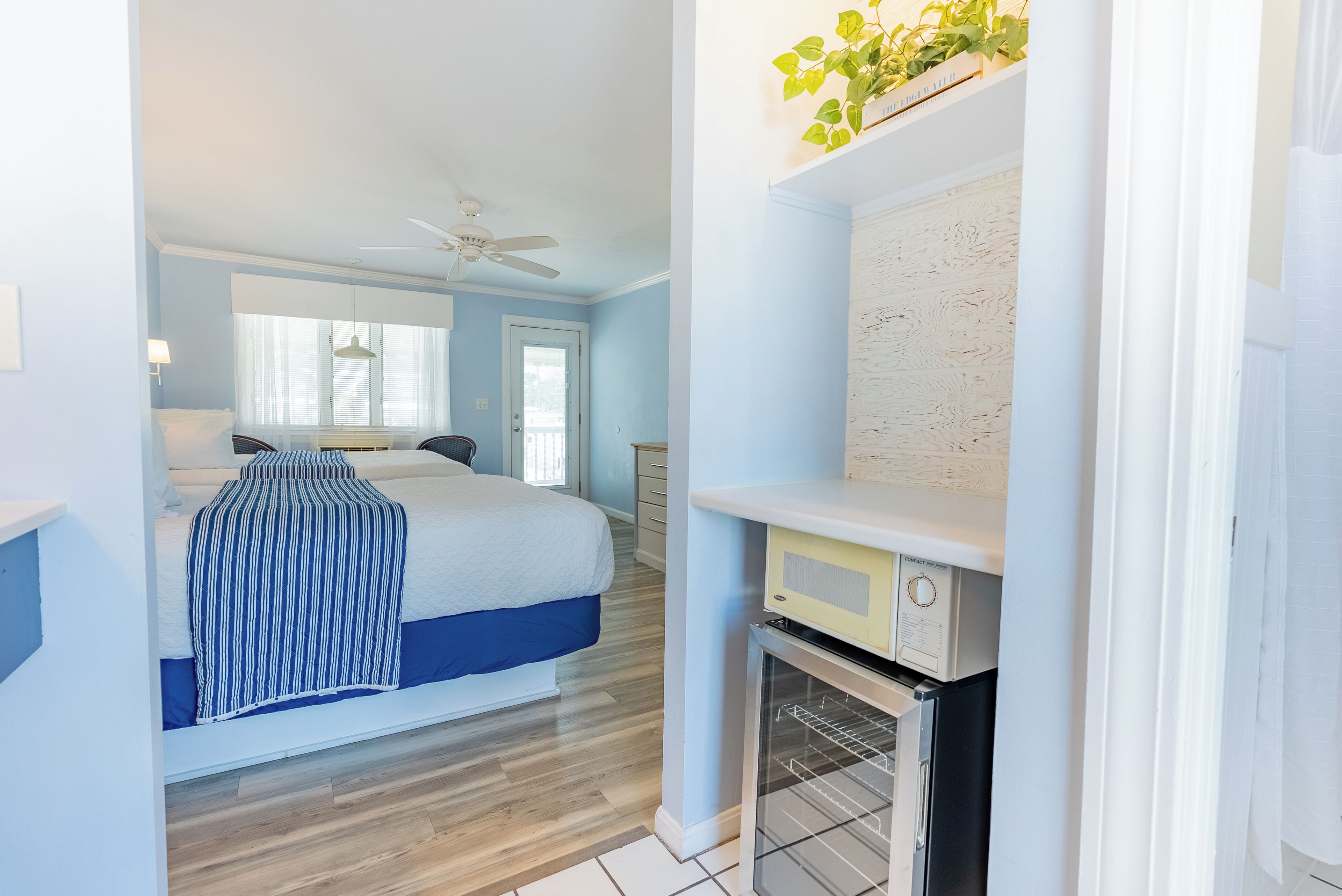 A bedroom with a bed, a ceiling fan, and a window with blinds.