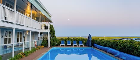 En säsongsöppen utomhuspool och solstolar