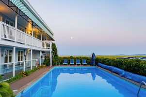Una piscina al aire libre de temporada, sillones reclinables de piscina