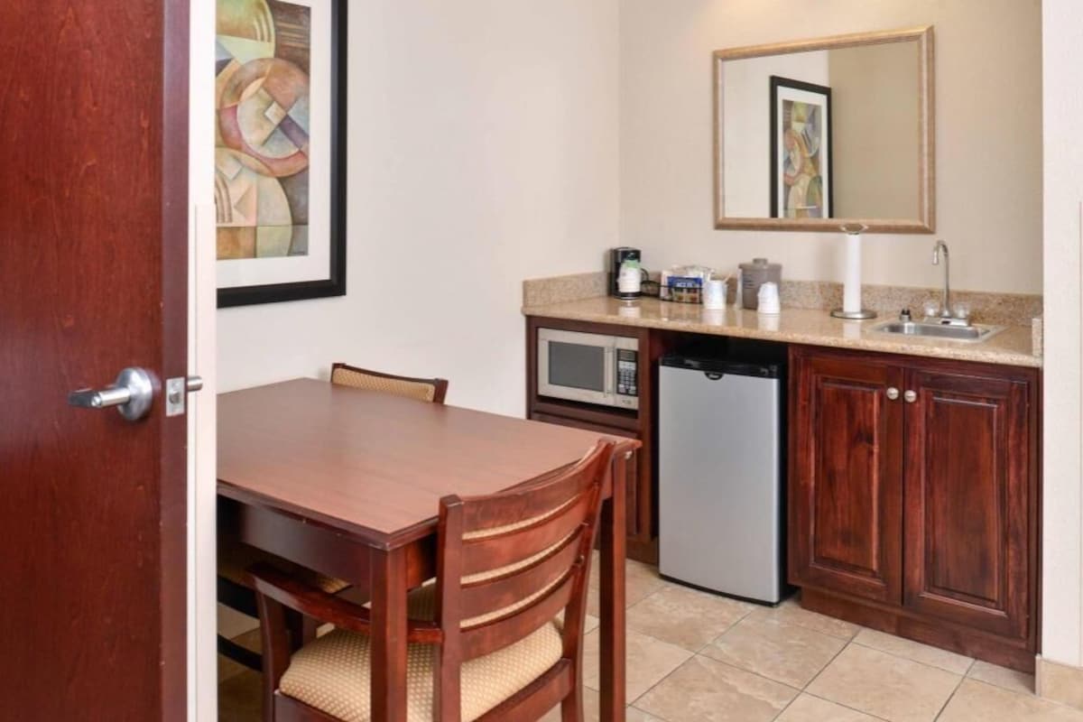 A compact kitchen with a microwave, refrigerator, and sink.