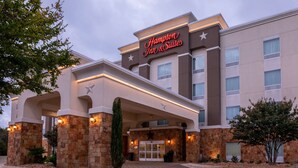 A Hampton Inn & Suites hotel with a stone facade, large entrance, and illuminated signage. - Hampton Inn & Suites Boerne (Boerne)