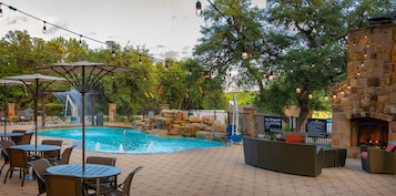 Una piscina al aire libre, sillones reclinables de piscina