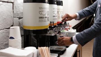 A coffee machine with a label stating '100% Arabica Beans' and 'Sourced from Central America & South America.'