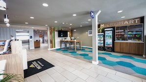 A modern interior with a reception desk, a seating area, and a Micromart store.