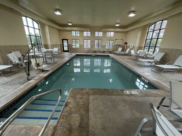An indoor swimming pool with clear lanes, lounge chairs, and a lifeguard station. - Staybridge Suites Lansing - Okemos by IHG (Okemos)