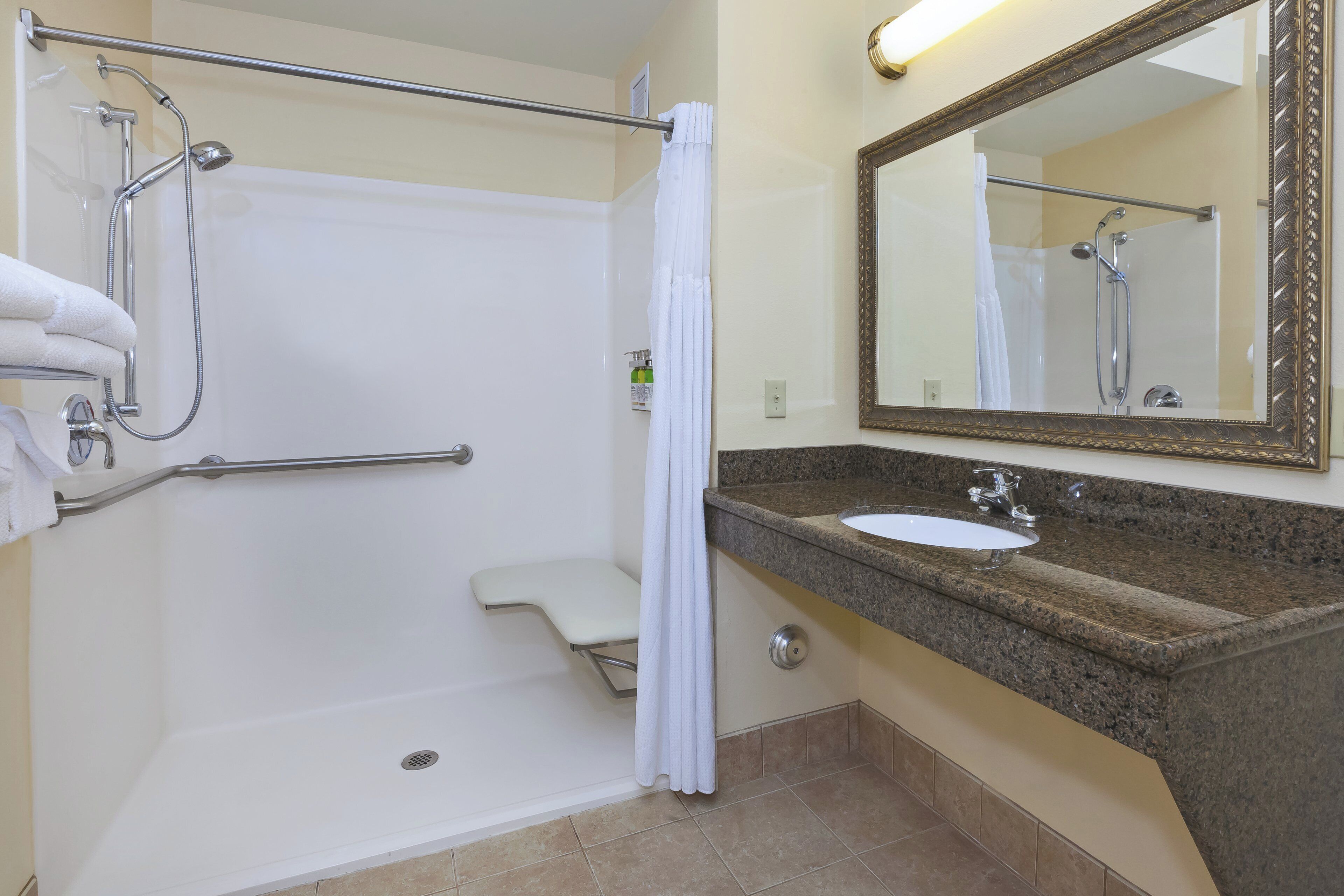 Une salle de bain équipée d’une douche, de toilettes, d’un lavabo et d’un miroir.