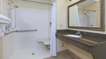 Une salle de bain équipée d’une douche, de toilettes, d’un lavabo et d’un miroir.