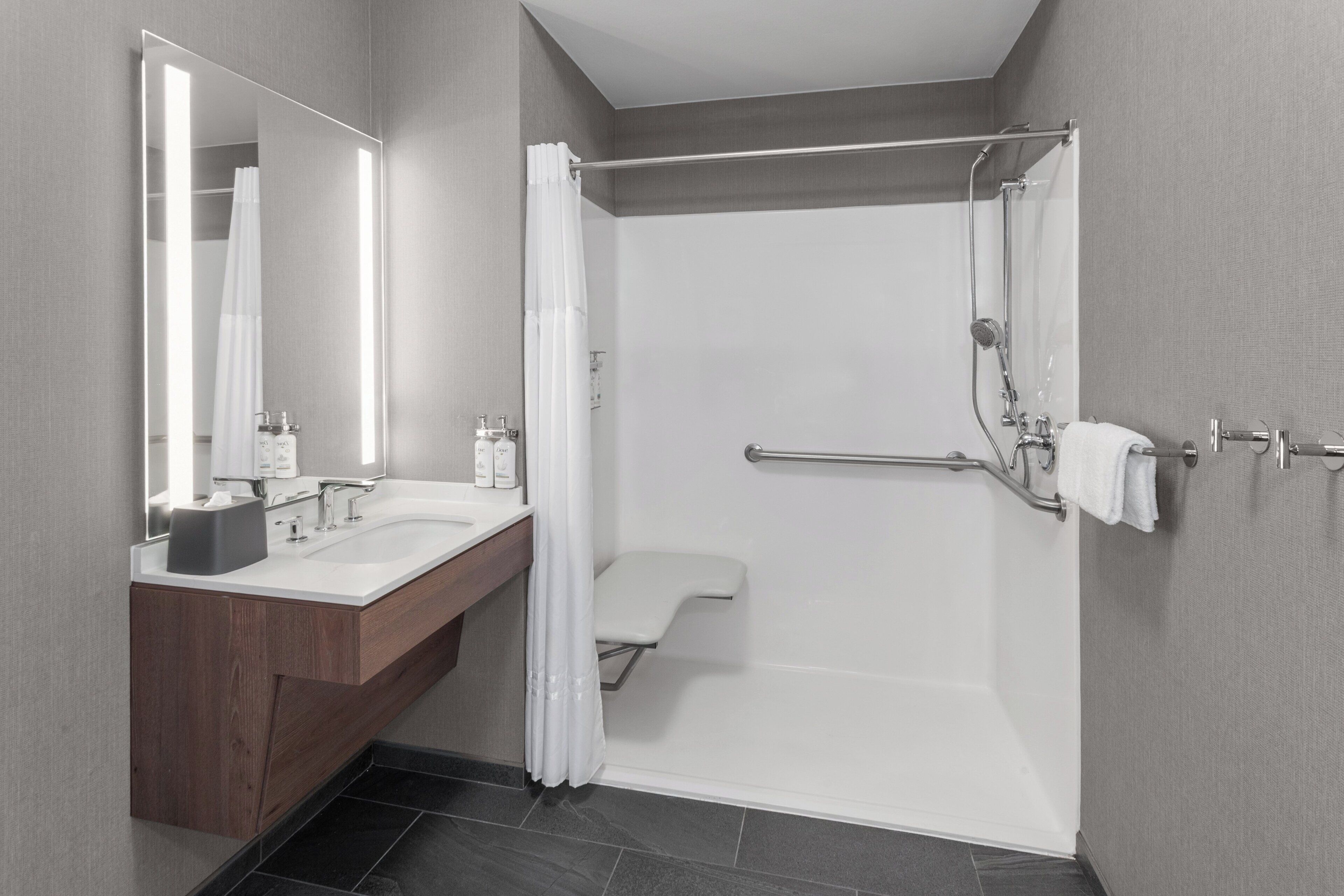 A modern bathroom with a double sink vanity, a shower with a glass door, and a towel rack.