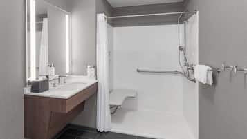 A modern bathroom with a double sink vanity, a shower with a glass door, and a towel rack.