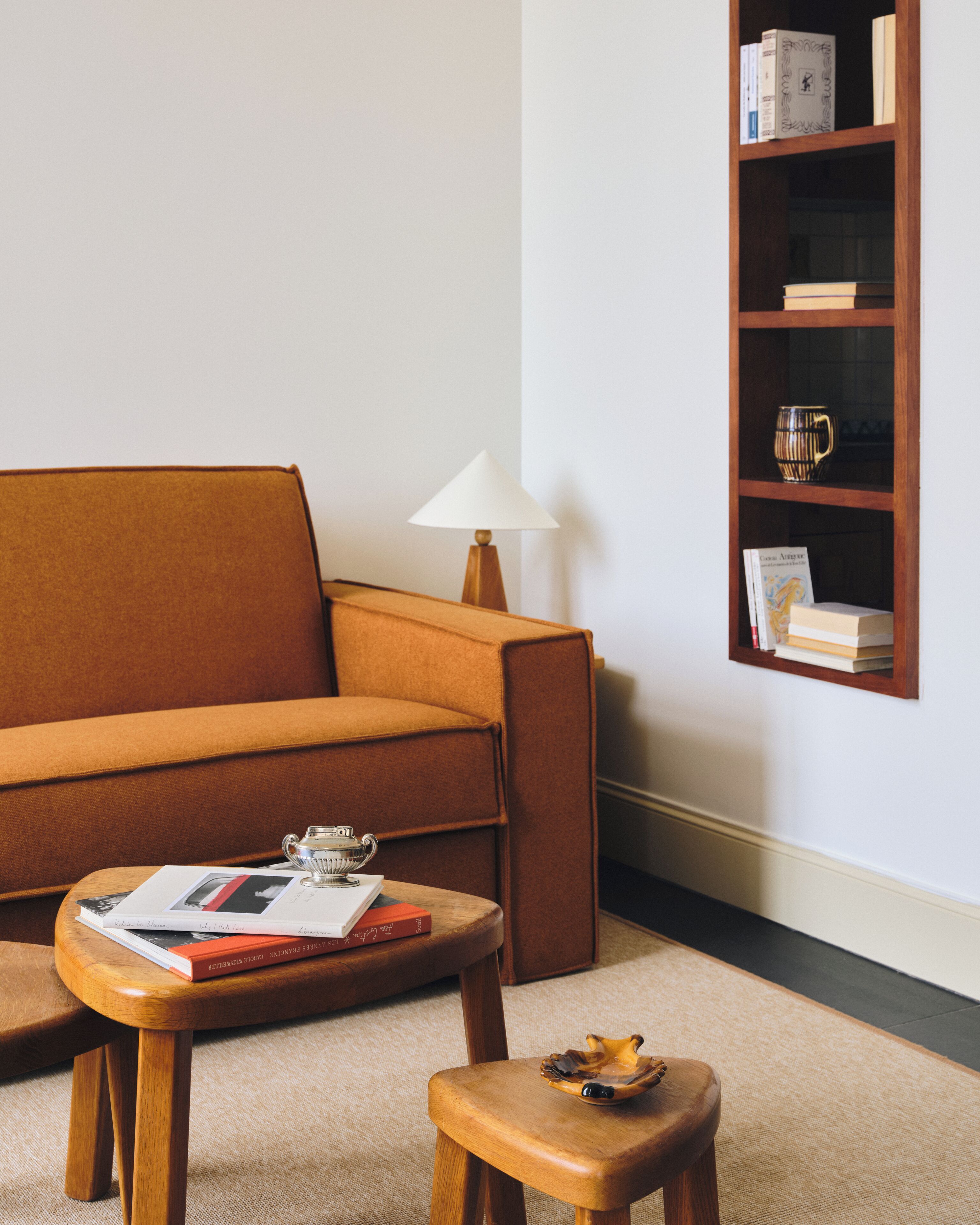 A living room with a sofa, a coffee table, a side table, a lamp, and a bookshelf.