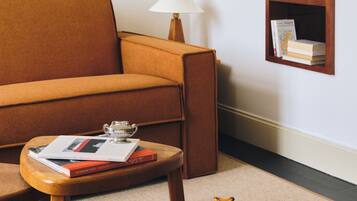 A living room with a sofa, a coffee table, a side table, a lamp, and a bookshelf.