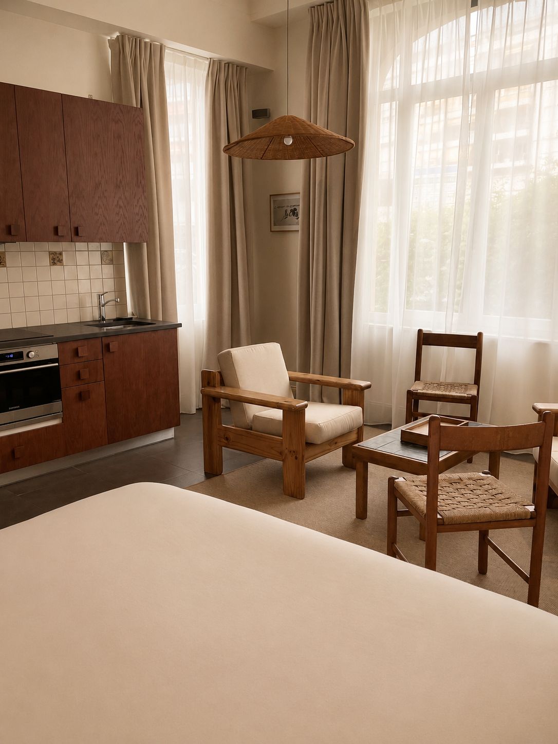 Una cucina moderna con mobili in legno, forno integrato e zona pranzo con tavolo e sedie in legno.