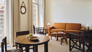 Une pièce comprenant une table ronde en bois, un canapé et deux chaises.
