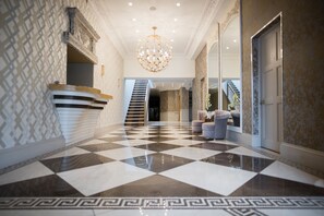 Experience the epitome of luxury in our elegantly designed lobby, featuring a grand chandelier, plush seating, and a reception desk.