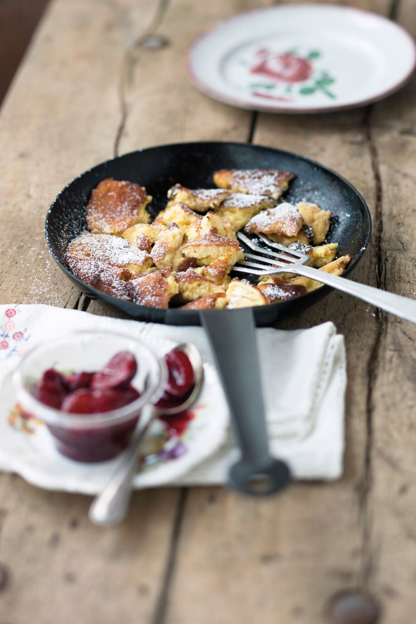 A skillet with a dessert, possibly bread pudding, on a wooden table.