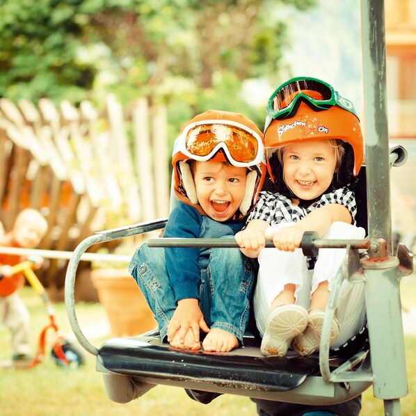 Dos niños con casco andando en un vehículo.