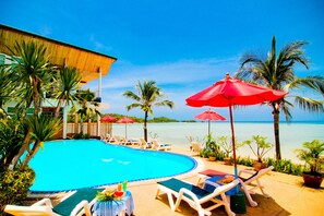 Una piscina al aire libre, sombrillas