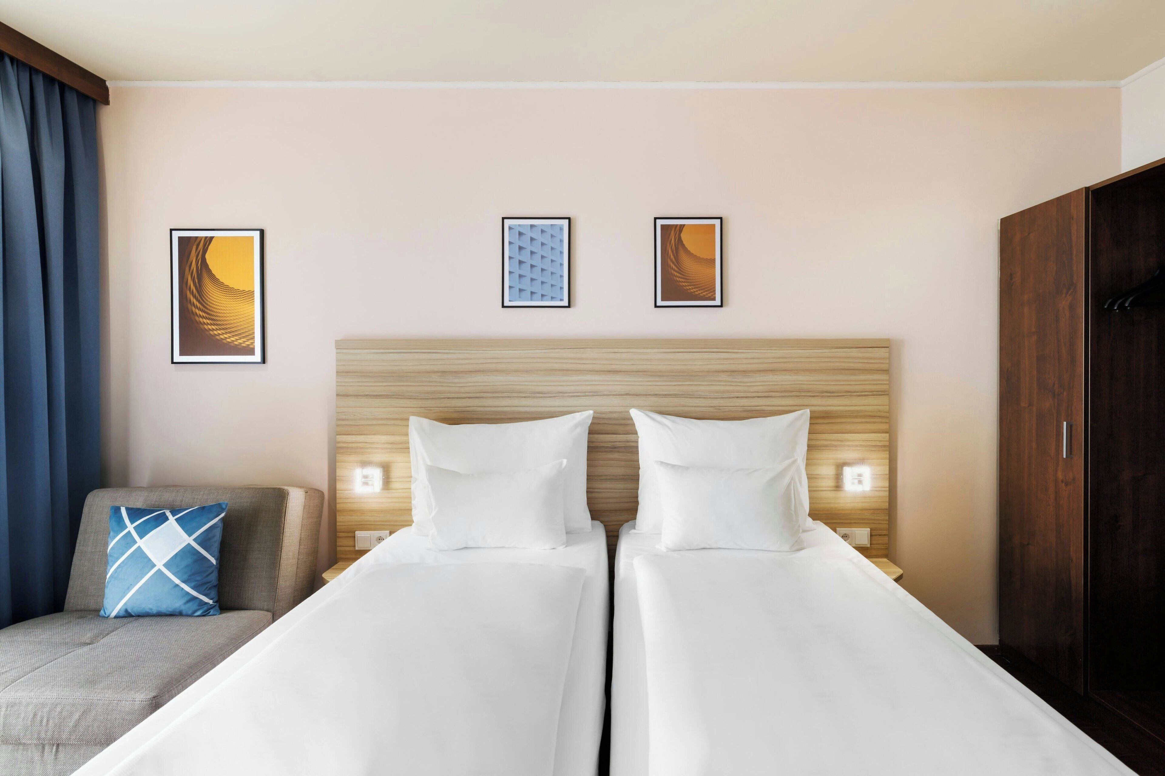 Habitación de hotel con dos camas, un sofá y un armario.
