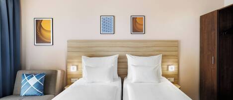 Habitación de hotel con dos camas, un sofá y un armario.