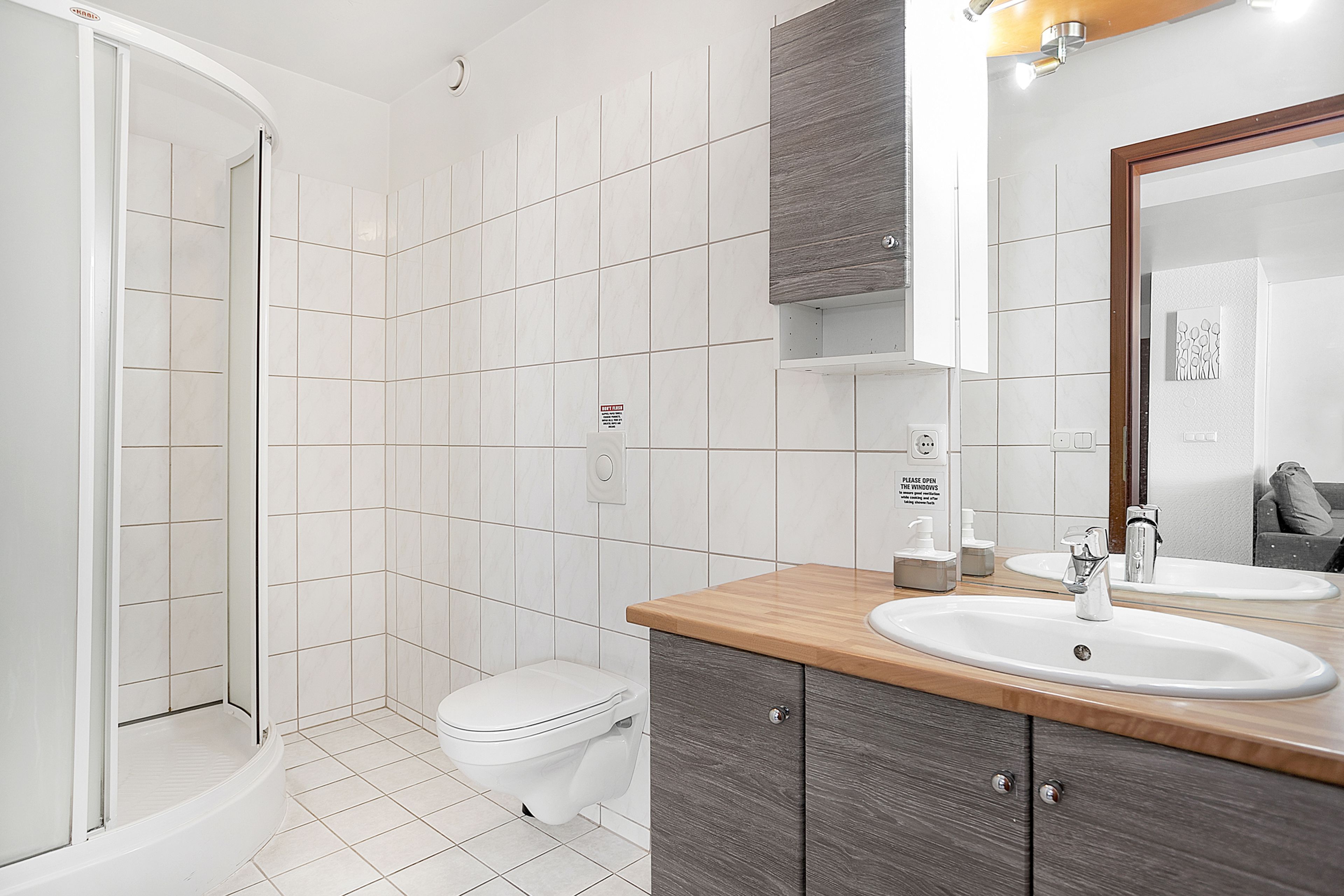 Ein modernes Badezimmer mit Dusche, Toilette und zwei Waschbecken.