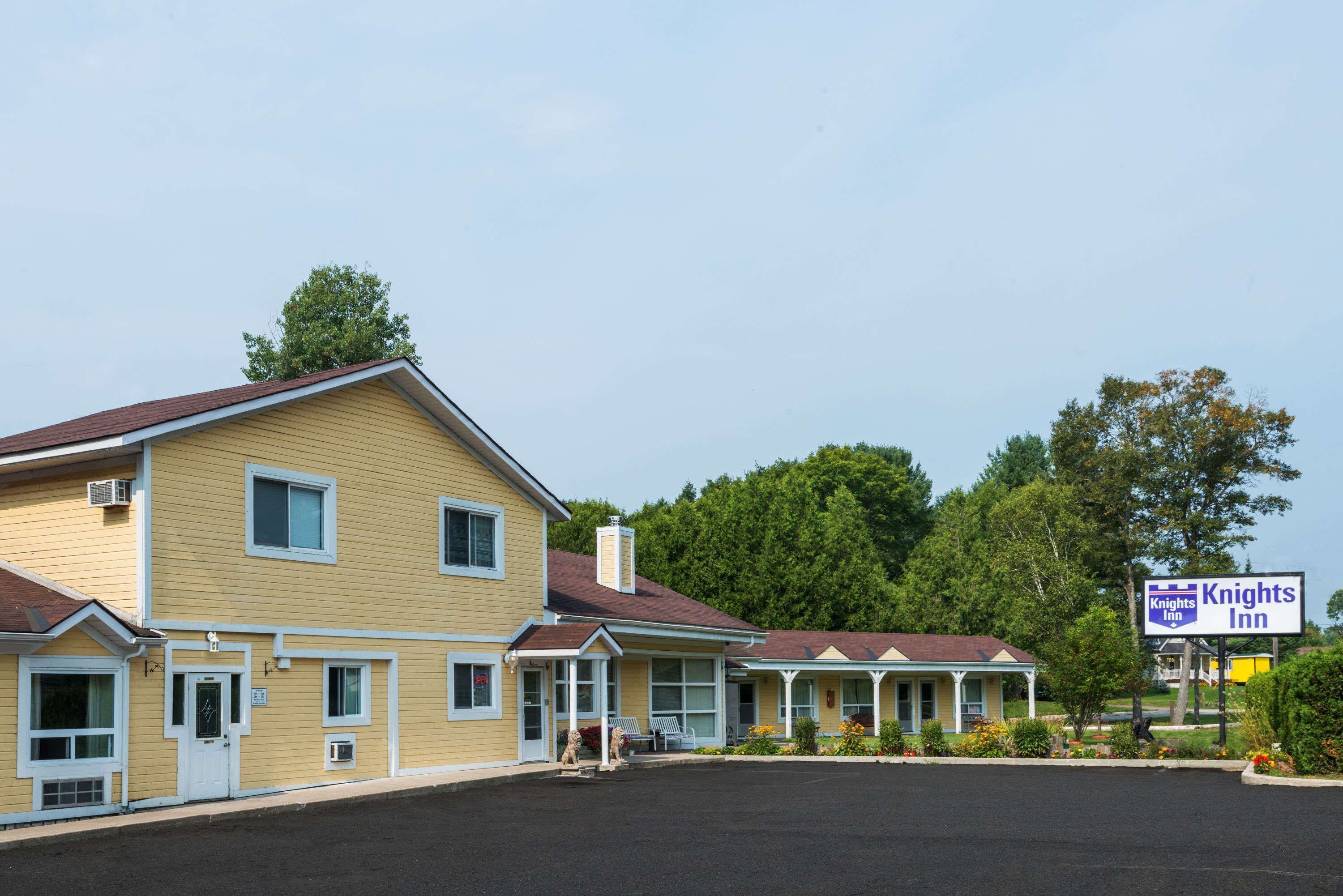 A yellow motel with a sign for Knights Inn.