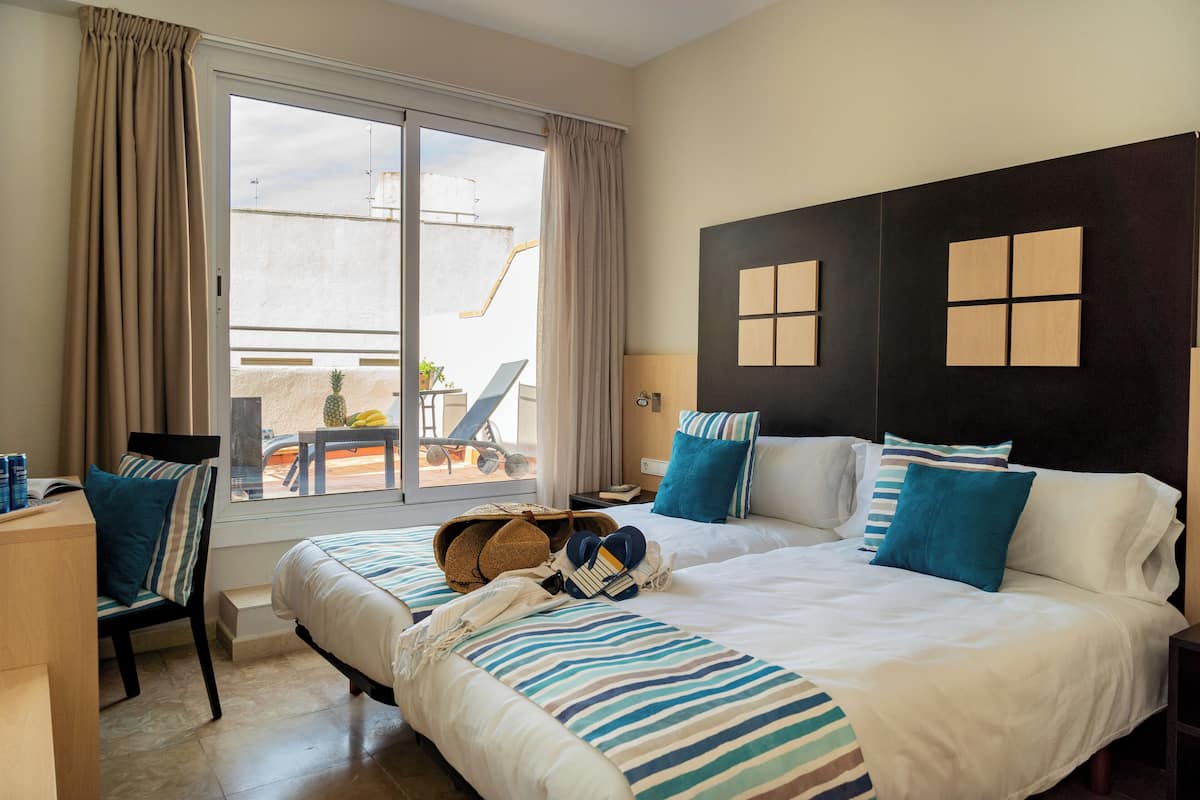 Une chambre d’hôtel avec un grand lit, un bureau et une vue sur le balcon extérieur.