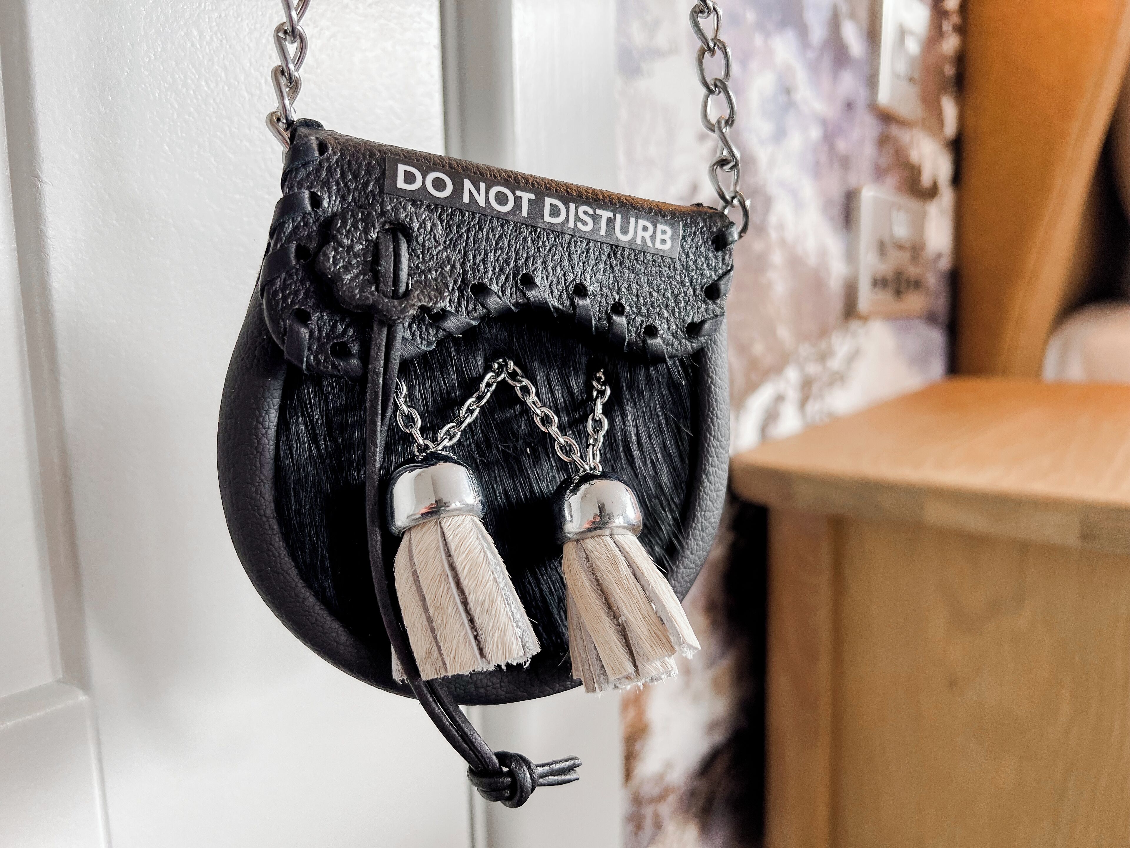 Eine schwarze Tasche mit einem 'DO NOT DISTURB'-Schild an einer Tür.
