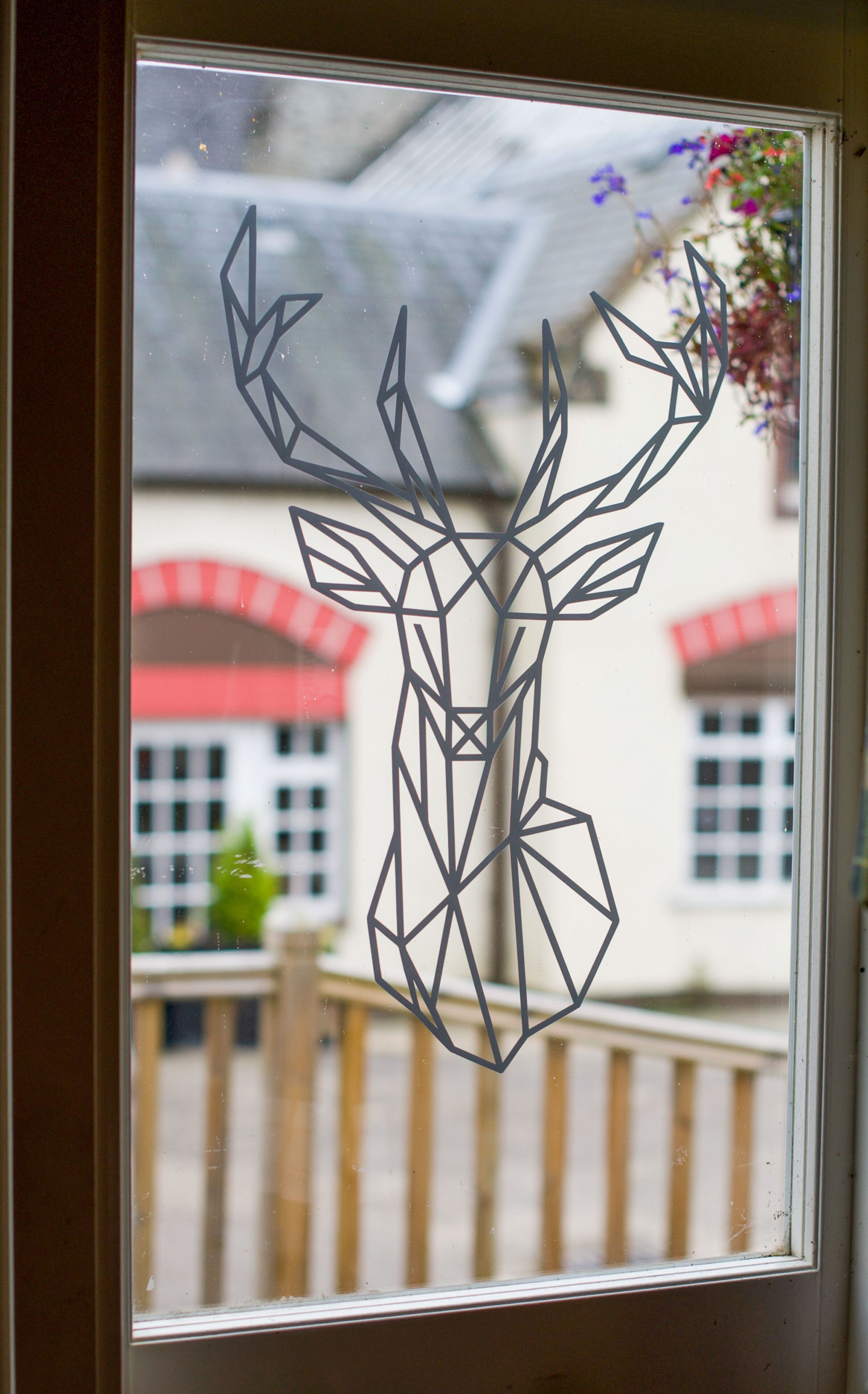 Ein geometrisches Hirschdesign auf einer Fensterscheibe.