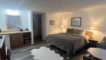 A bedroom with a bed, bedside tables, a desk, and a chair.