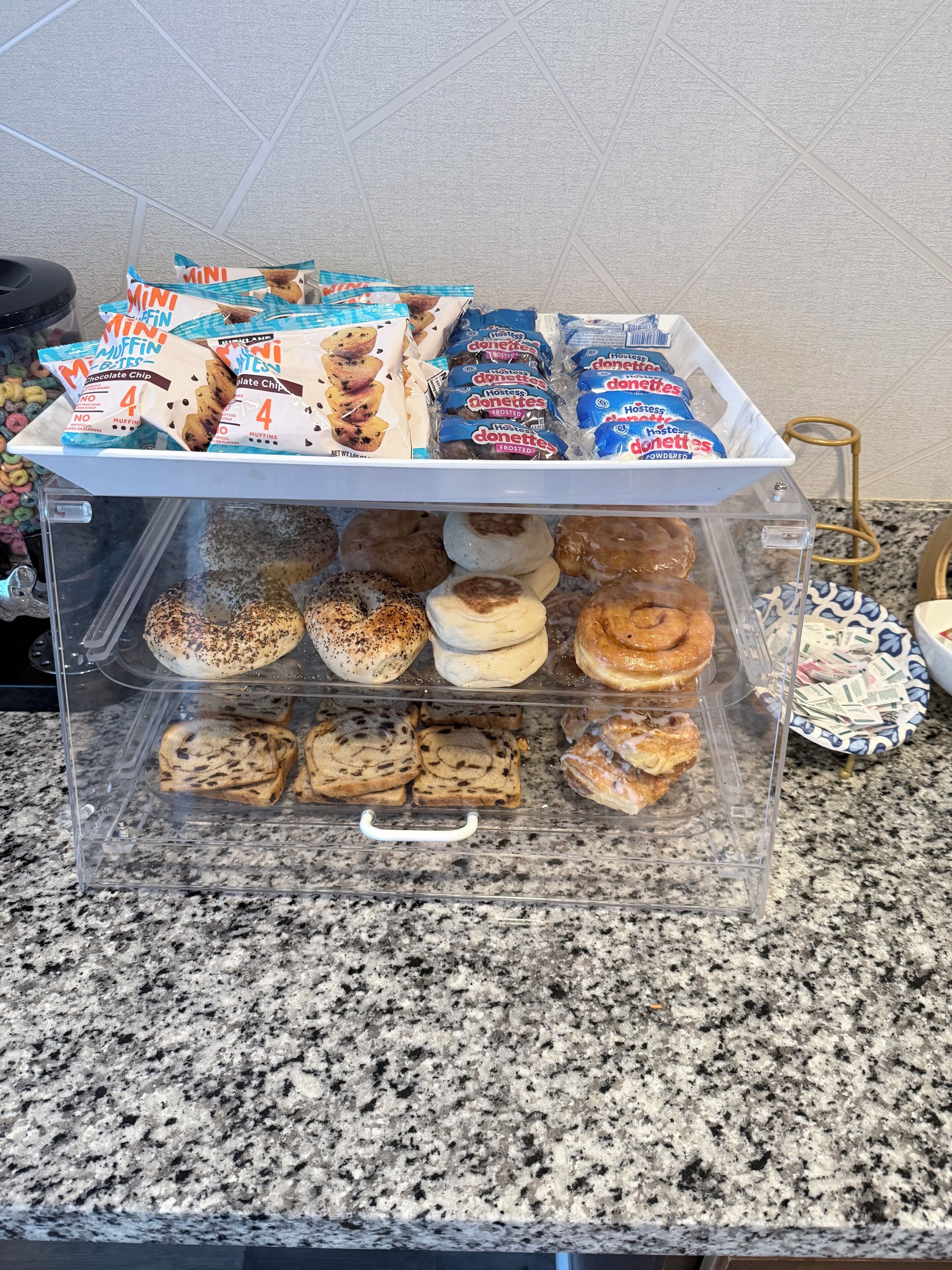 Eine Vitrine mit verschiedenen Muffins und Donuts, darunter Schoko-Chip- und Zuckergussvarianten.